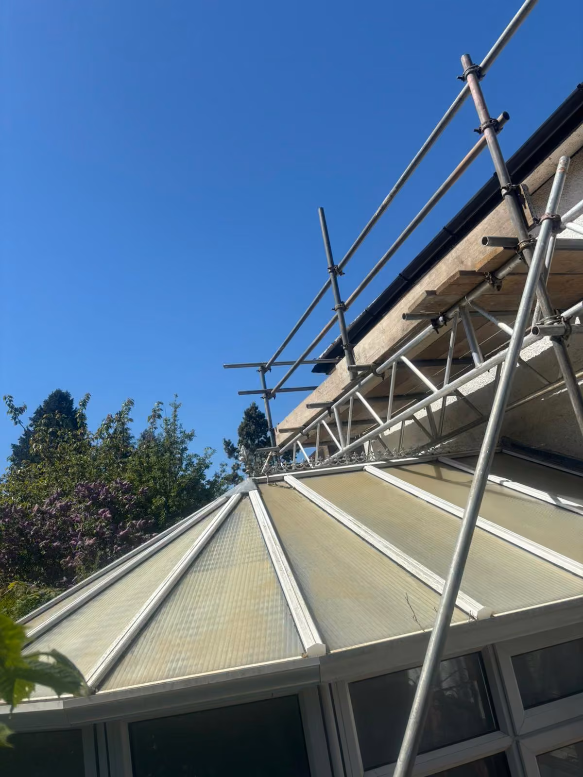 Scaffold bridged over a conservatory